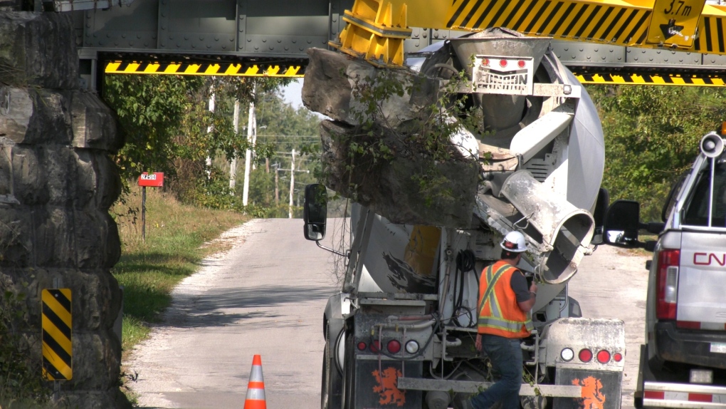 Truck wedged beneath CN train bridge [Video]